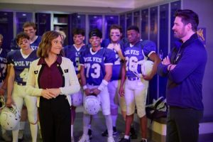 Nikki DeLoach and Warren Christie and a bunch of football players in Home Turf. Photo: Hallmark Channel