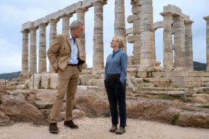 Hugh Laurie and Amy Poehler standing at the base of a Greek temple in Dig. Photo: Peacock