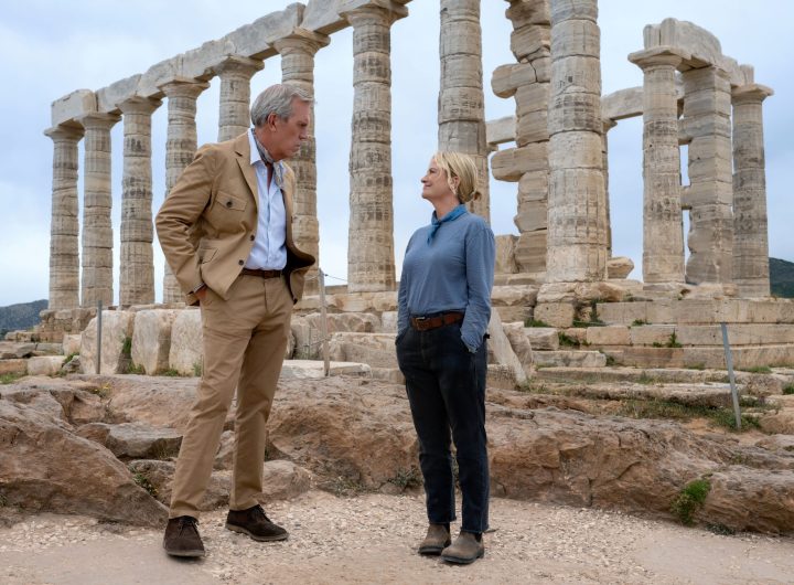 Hugh Laurie and Amy Poehler standing at the base of a Greek temple in Dig. Photo: Peacock